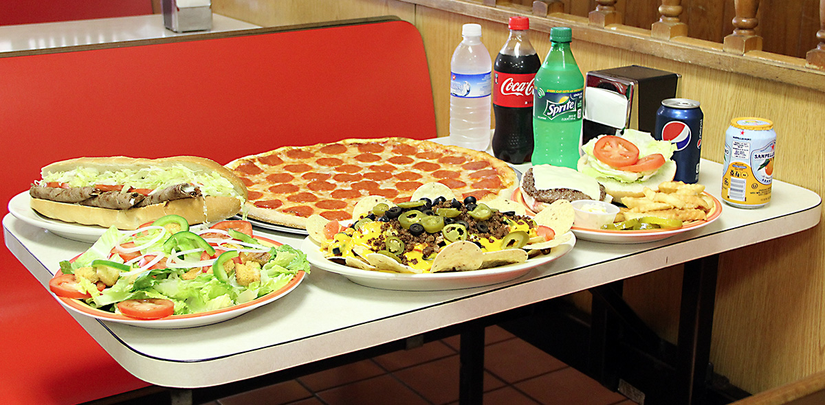 Photo of a steak sandwich, salad, pizza, appetizer, hamburger platter, and soft drinks on a table in AlJons